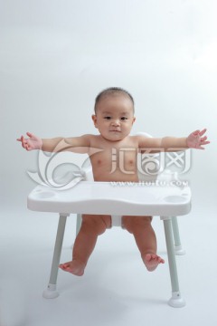 胖胖婴儿坐在餐桌餐椅手舞足蹈
