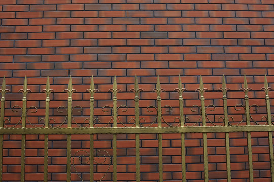 古铜色的铁艺栏杆与红色瓷砖墙面
