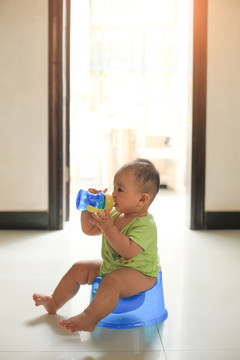 胖胖的宝宝坐在马桶上自己喝水