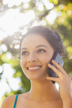 微笑的女人在用手机打电话