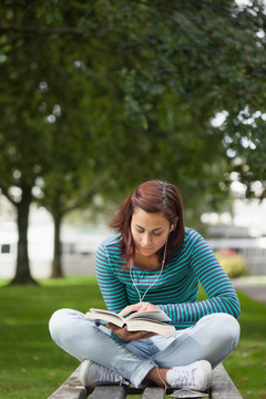 坐在公园长椅上看书的女学生
