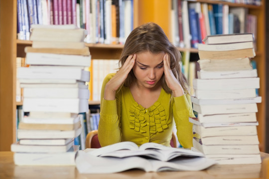 疲惫的女学生在图书馆里学习