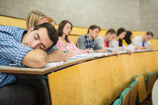 趴在桌上睡觉的男学生