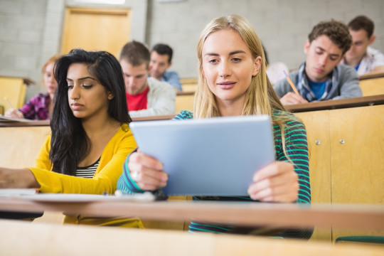 在教室里使用平板电脑的女大学生