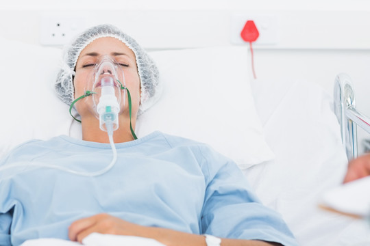 躺在床上带氧气面罩的病人