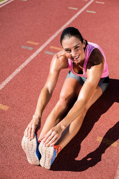 女运动员在跑道上做热身