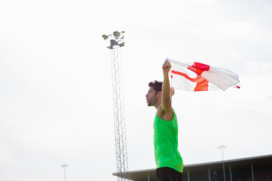 胜利的男运动员拿着英格兰国旗