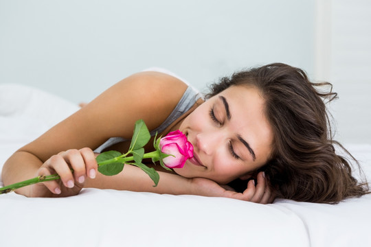 躺在床上闻一朵花香的女人