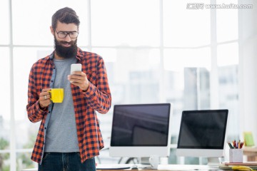 边喝咖啡边使用手机的男商人