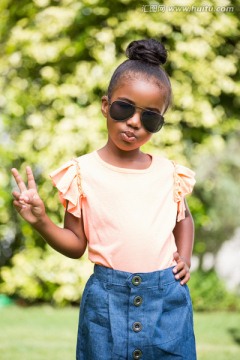 在公园里戴着太阳眼镜的小女孩
