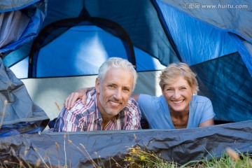 微笑的中年夫妇趴在帐篷里