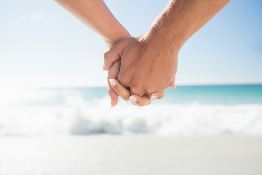 在海边牵着手的情侣