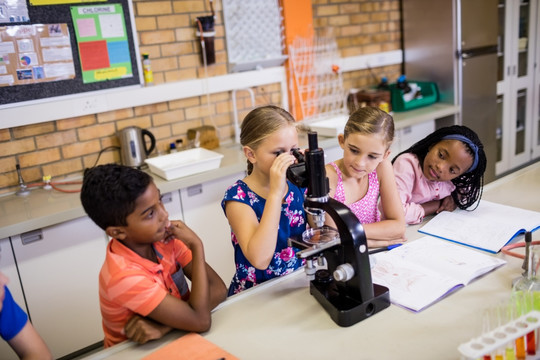 儿童在显微镜下观察