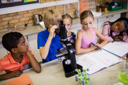 儿童在显微镜下观察
