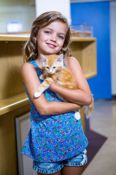 微笑着抱着小猫的小女孩