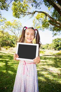 小女孩在公园里拿着平板电脑