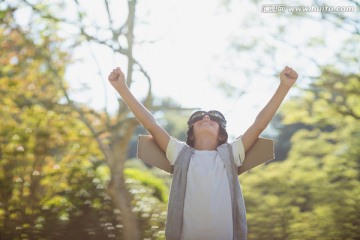 在公园里举起双臂的小男孩