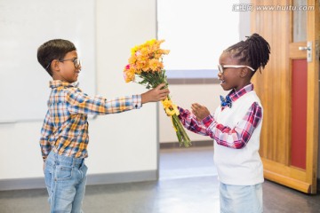 男学生在教室里送一束花给女学生