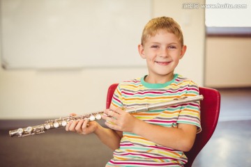 在教室里吹长笛的男学生