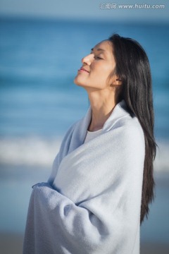 在海边裹着毛巾的女人