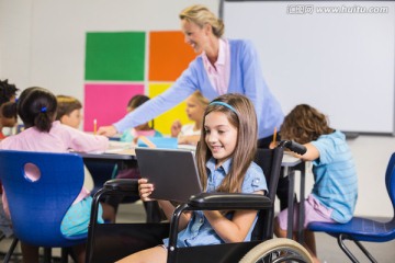 残疾女学生坐在轮椅上用平板电脑