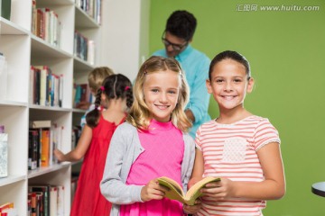 微笑的两名学生在图书馆里看书