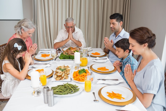 在用餐前祈祷的家人