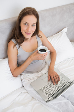 在床上使用笔记本电脑的女人