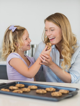 微笑的女孩给妈妈喂小饼干