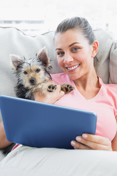 在用平板电脑的女人和她的宠物狗