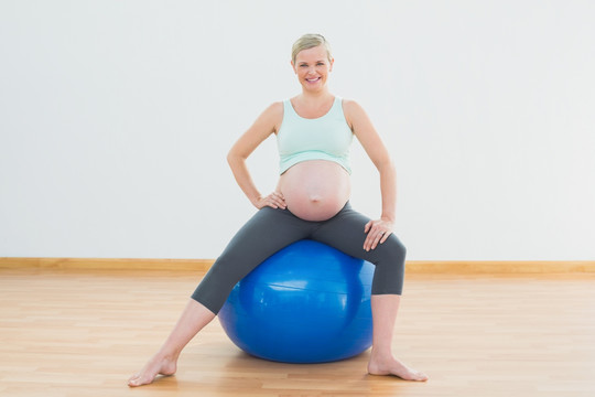 坐在瑜伽球上健身的孕妇