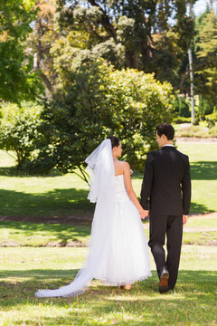走在公园草坪上的新郎新娘