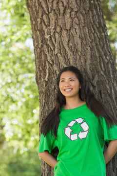 穿着回收T恤的年轻女人站在树下