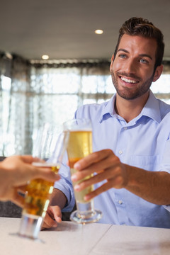 微笑着喝啤酒的商务男人