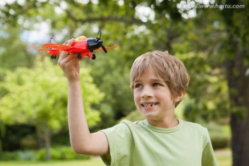 兴奋的小男孩在公园里玩飞机
