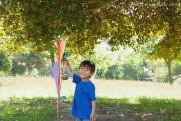 在公园里放风筝的小男孩