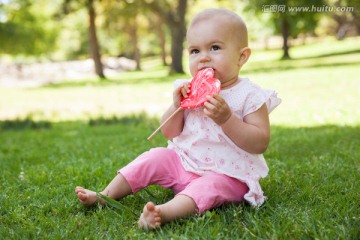 可爱宝宝在公园拿着心形棒棒糖