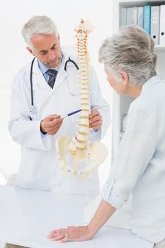 男医生向老年患者解释脊柱