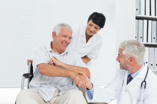 老年患者和医生在医务室握手