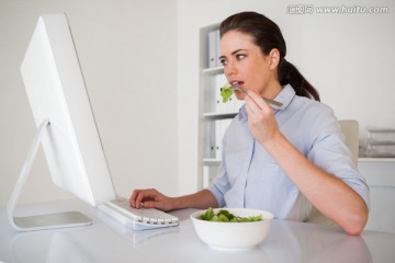 吃着沙拉在电脑上工作的商务女人