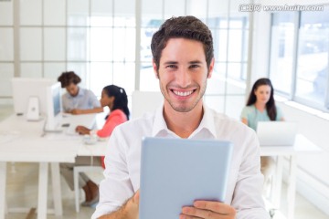 微笑着拿着平板电脑的男人