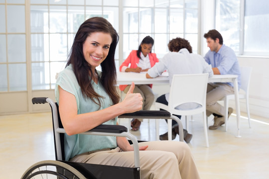 坐在轮椅上竖起大拇指的女人