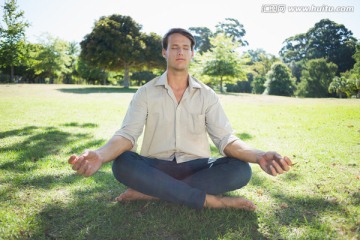 坐在公园草地上冥想的男人