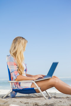 在海边用笔记本电脑的女人