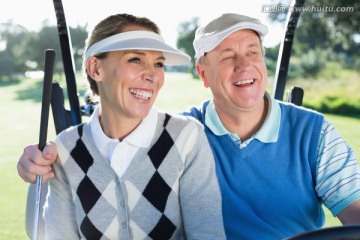 快乐的老夫妇坐在高尔夫球车上
