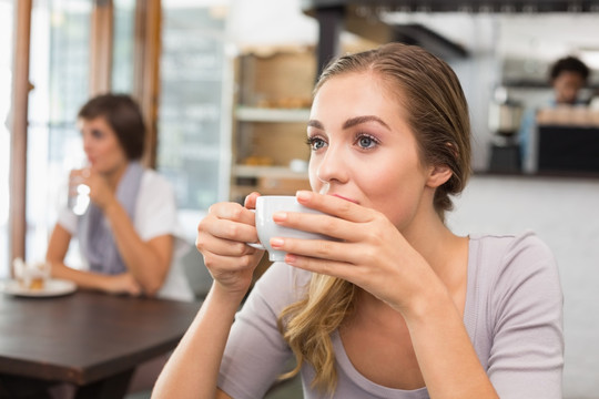 坐在咖啡店喝咖啡的女人