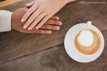 桌上的一杯咖啡和情侣的手