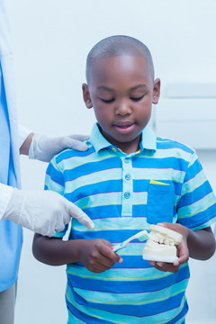在指导小男孩清洗牙齿的医生