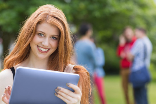 微笑的女人在用平板电脑