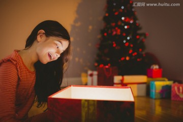 小女孩打开一个发光的圣诞礼物